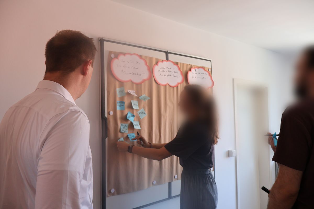 Drei Personen vor einer Pinnwand mit Karten zur Frage, was Studierende zum Lernen nutzen